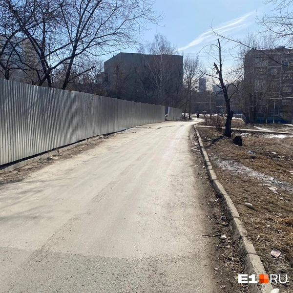 Жильцы домов уже лишились пешеходной зоны, идти вдоль забора теперь нужно по дороге | Источник: читатель E1.RU