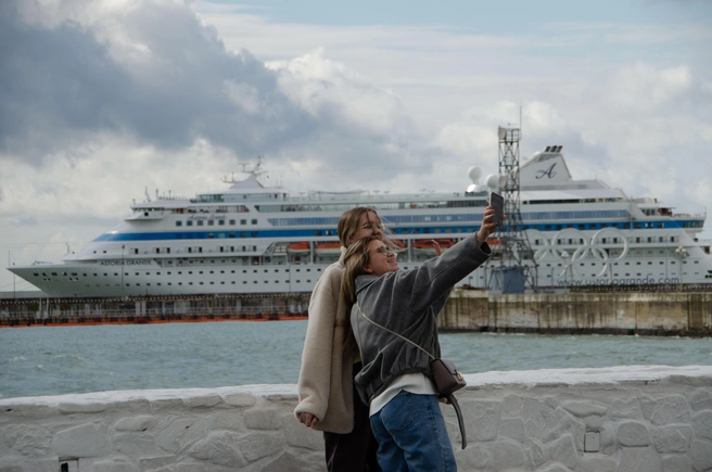 Туристки делают памятное селфи на набережной Сочи на фоне круизного лайнера | Источник: Оксана Витязь / SOCHI1.RU