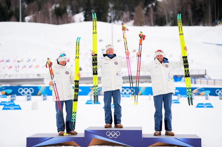 Обладатель золотой медали Йоханнес Хесфлот Клебо празднует победу вместе с серебряным призером Мартином Левстремом Нюэнгетом и бронзовым призером Эмилем Иверсеном на Олимпиаде-2026 | Источник: NordicFocus
