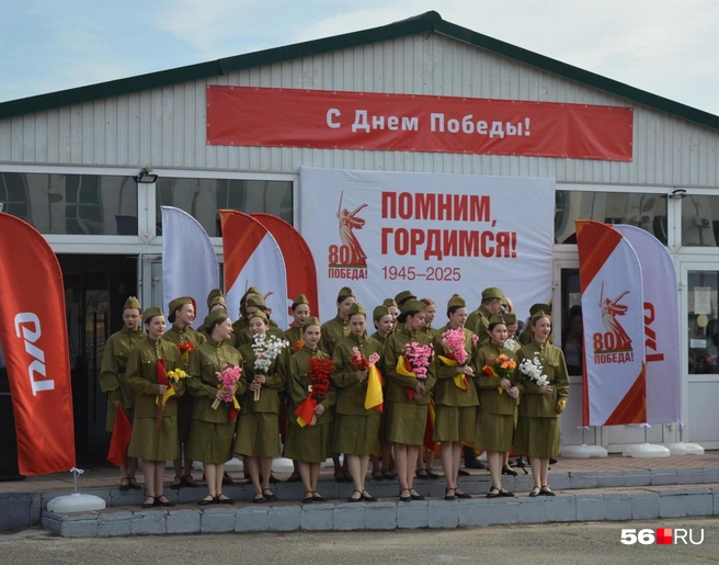 Девушки в военной форме с цветами в руках | Источник: Анастасия Баринова / 56. RU