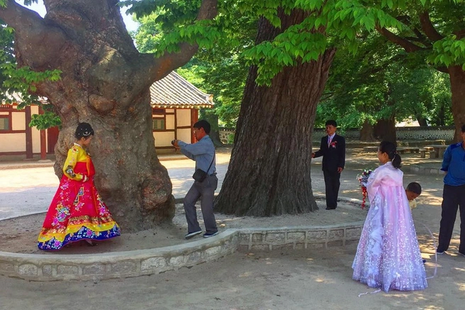 Невеста — в разноцветном, свидетельница — в сиреневом | Источник: dprk_tours / Instagram* (деятельность соцсети запрещена на территории РФ)