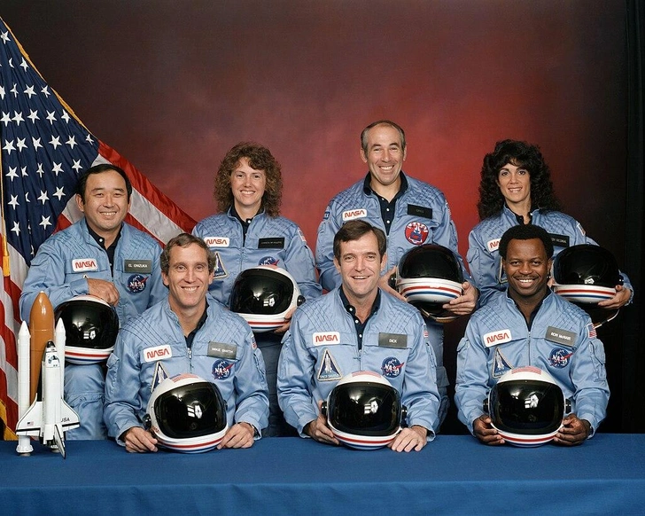 Экипаж STS-51L. Позади слева направо: Эллисон С. Онидзука, Шэрон Криста Маколифф, Грег Джарвис и Джуди Резник. Спереди слева направо: Майкл Дж. Смит, Дик Скоби и Рон Макнейр. Официальный портрет НАСА от 15 ноября 1985 года | Источник: NASA / wikipedia.org