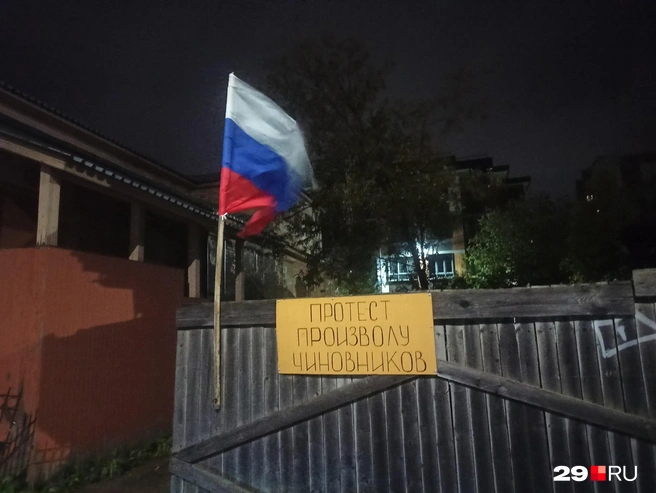 Водитель прикрепил на забор лозунг и флаг | Источник: Ярослав Вареник / 29.RU