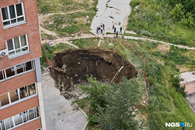 В яму упали деревья и забор | Источник: Александр Ощепков / NGS.RU