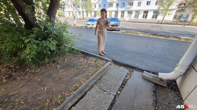 Екатерина показывает, чтобы новый асфальт сделали без ливневого водостока | Источник: Александр Лисихин / 45.RU 