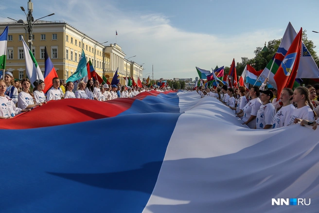Вечером на стадионе «Динамо» также начался Парад национальностей, во время которого сотни участников несли огромный флаг России до площади Минина | Источник: Наталья Бурухина