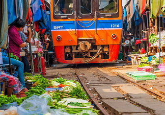 Тайские продавцы убирают товары с пути поезда