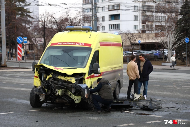 Пока водитель скорой осматривает колеса, рядом стоят водитель и пассажир из Mercedes | Источник: Михаил Шилкин 