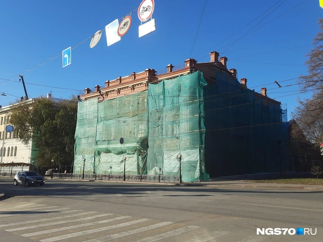 Фасад реставрируют, поэтому здание укутали в зеленую сетку | Источник: Анастасия Харламова / NGS70.RU