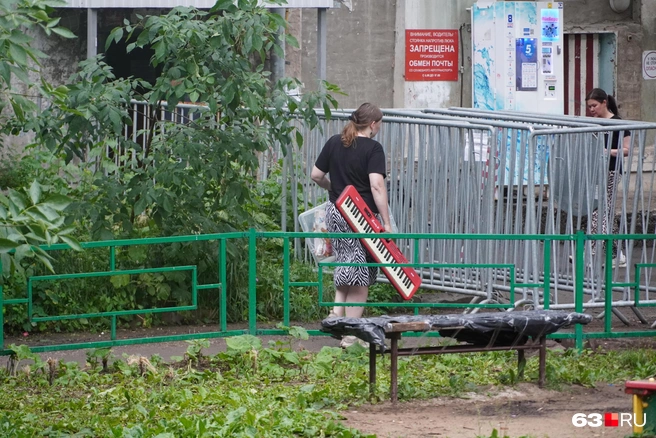 Девушка вынесла из дома клавишный инструмент | Источник: Алексей Ногинский / 63.RU
