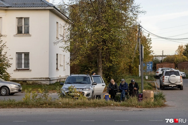Местные жители отдыхают на скамейке у шоссе, проходящего через поселок | Источник: Александр Куренной / 76.RU