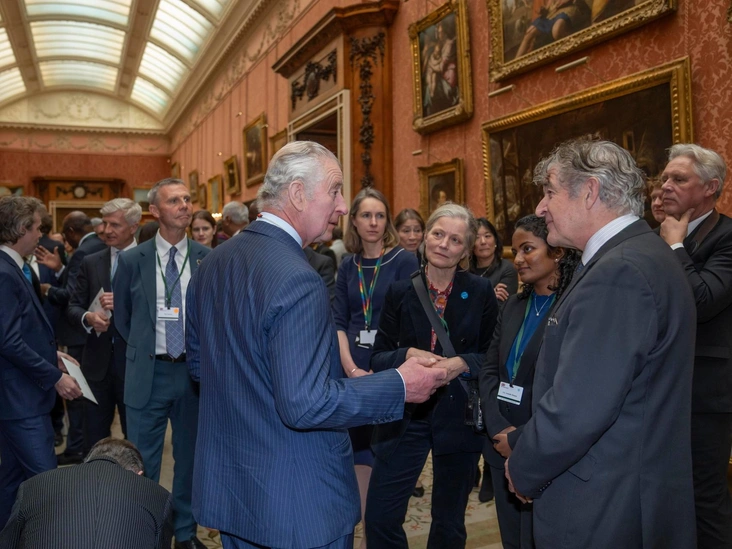 Карл III беседует с Тони Джунипером, председателем организации Natural England (справа), во время приема в Букингемском дворце, 17 февраля 2023