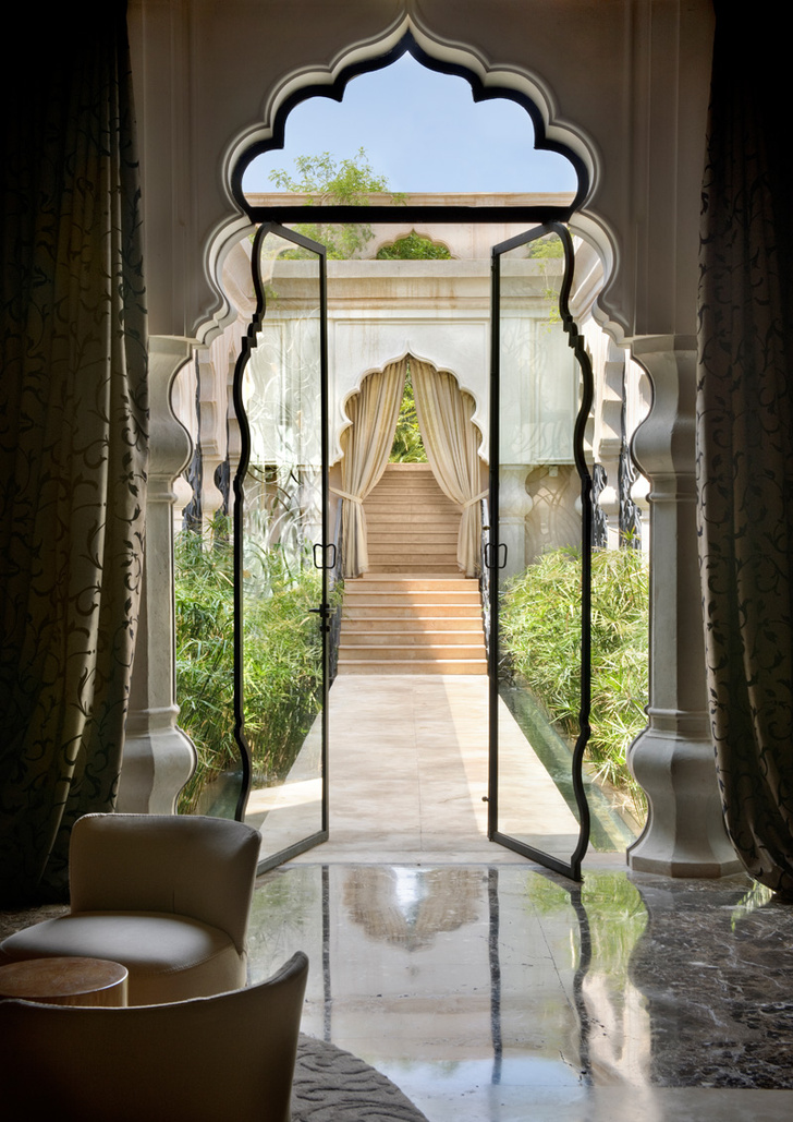 Лобби отеля. Высокие стеклянные двери помогают визуально стереть границу между интерьером и садом.