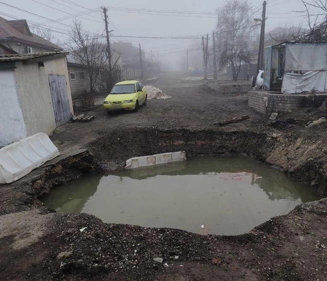 Наливные блоки, которыми была огорожена яма, утонули в глубокой луже | Источник: читатели V1.RU