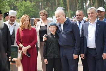 Женщина в красном платье — Лариса Назарова, по центру обнимает ребенка Андрей Назаров, слева от него — Алексей Горбачев | Источник: Андрей Назаров / Telegram