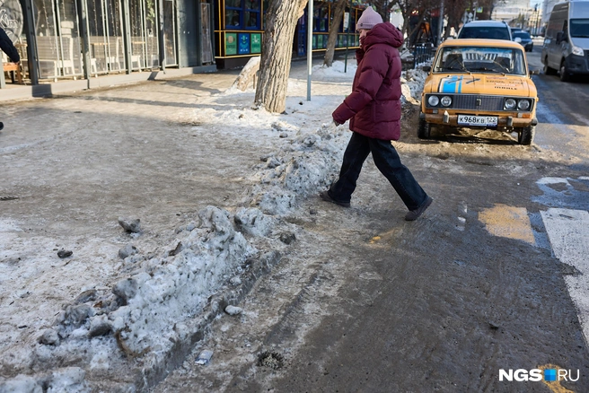 На пешеходных переходах помимо льда также образовались кучи твердого снега, что осложняет движение | Источник: Александр Ощепков / NGS.RU