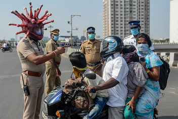 Индийский полицейский пугает нарушающих карантин коронашлемом