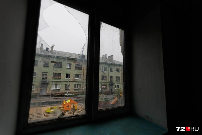 Вид из окна подъезда. Одно стекло разбито, а второе целое  | Источник: Ирина Шарова / 72.RU 