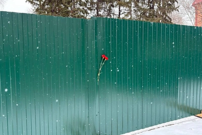 Томичи оставляют цветы у забора на месте Камня скорби