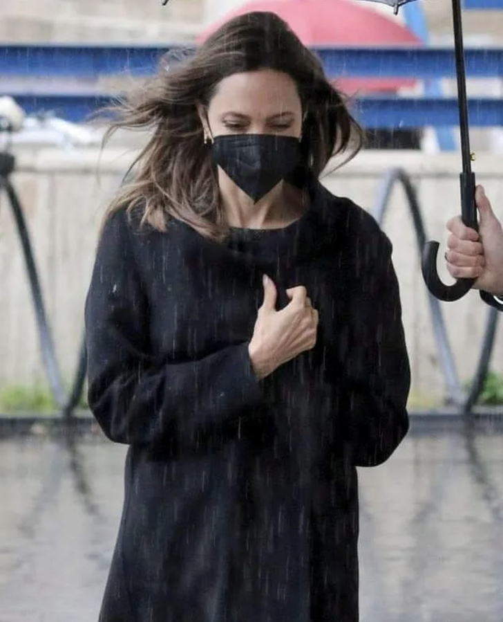 Очень чувственно: Анджелина Джоли в мокром платье-футляре гуляет под проливным дождем