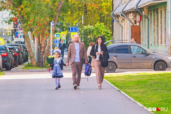 У мамы с папой очень сосредоточенные лица. Может быть, переживают, потому что дочка идет в первый класс?  | Источник: Тимофей Калмаков / 59.RU