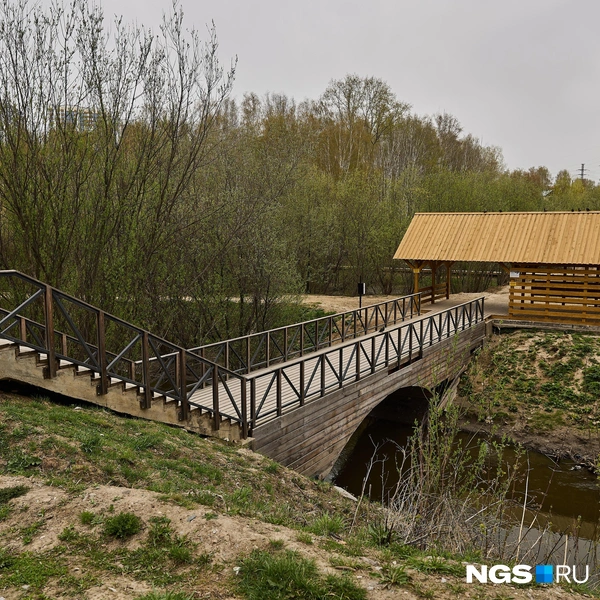 Одна из самых удобных входных групп в парк находится со стороны дома на улице Адриена Лежена, 17. Там обустроили спуск с мостиком и беседкой в виде водяной мельницы | Источник: Александр Ощепков / NGS.RU