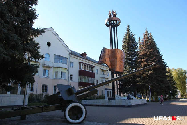 Рядом со стелой стоит гаубица