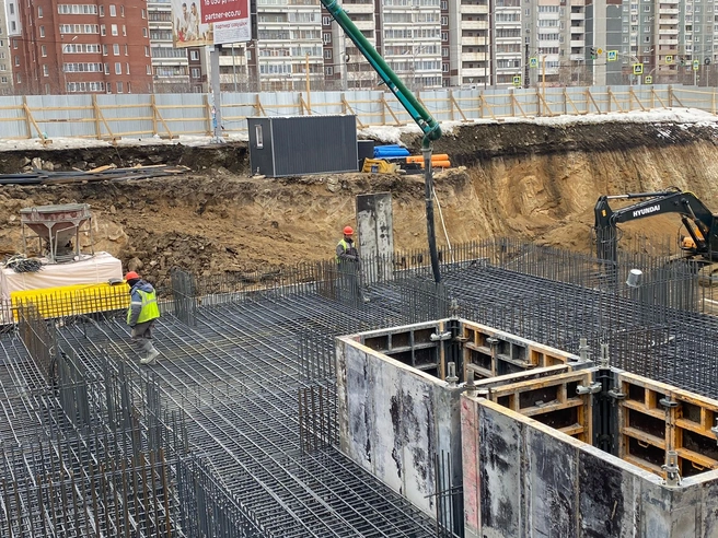 По зеленой трубе из приемного бункера автобетононасоса поступает бетон, которым заливают арматурную сетку фундаментной плиты | Источник: «НКС-Девелопмент»