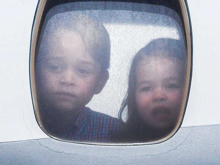 Джордж и Шарлотта выглядывают из самолета, прибывшего в Варшаву, во время официального визита Кембриджских в Польшу и Германию, 2017 год