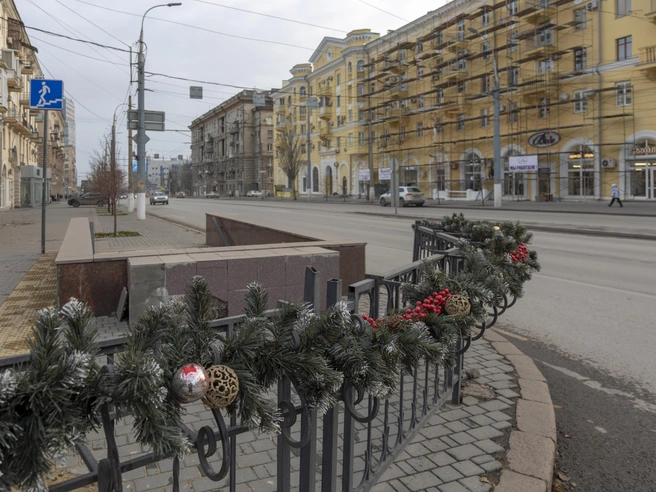 Ограждение на перекрестке Комсомольской и проспекта Ленина оплели гирляндой из искусственного лапника. | Источник: Константин Завриков / V1.RU