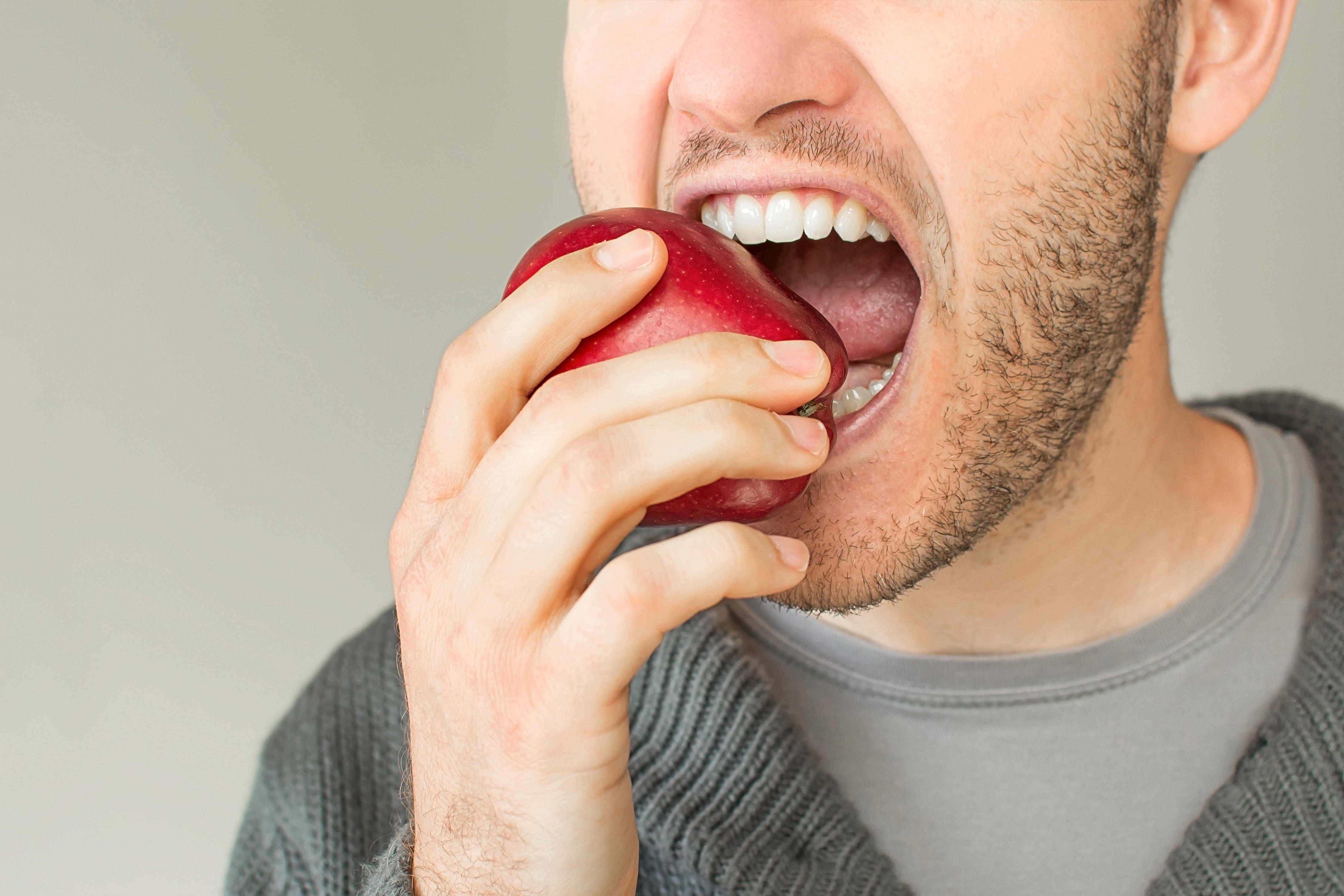 Мужчина ест яблоко
