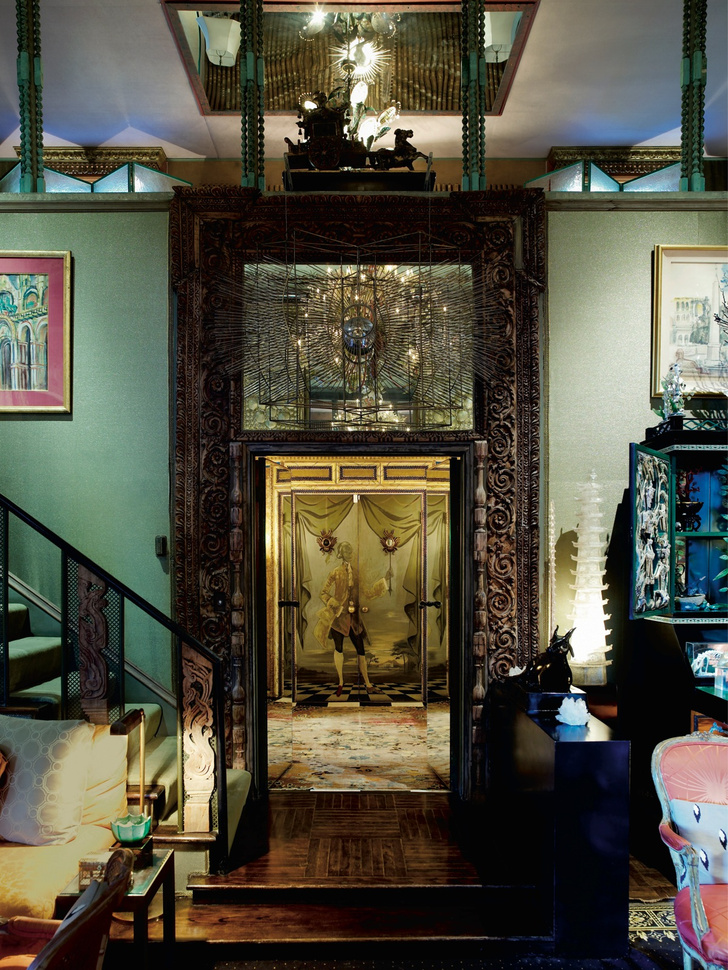 Лестничный холл. Над дверью с резным порталом — ­скульптура Тони Дюкетта «Солнце». В глубине — дверь, расписанная Элизабет Дюкетт.
