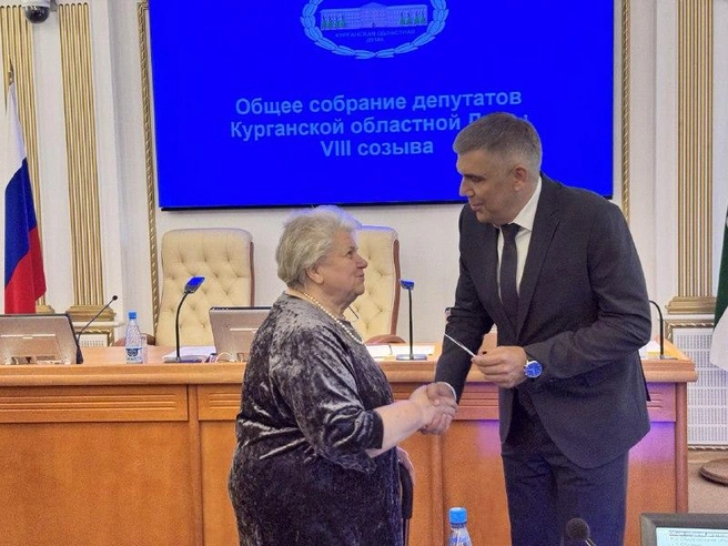 Роман Скиндерев вручает удостоверение избранного депутата Ольге Баланчук | Источник: Юлия Король / 45.RU