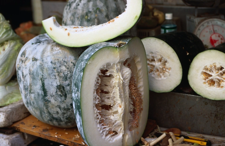 ЗИМНЯЯ ДЫНЯ (winter melon) внешне похожа на тыкву или огромный цукини, но мякоть у нее дынная, хоть и несладкая. Цена — 8 патак за фунт (~70 рублей за килограмм). Целая дыня используется для варки супа донгуатан: семенная часть вынимается, а внутрь закладываются креветки, мясо, грибы, травы и наливается бульон. Все это ставится в пароварку. Готовый суп вычерпывается из дыни вместе с мякотью прямо в миски. Но это удовольствие для большой компании. Часто дыню продают кусками | Источник: Oliver Strewe / Getty Images