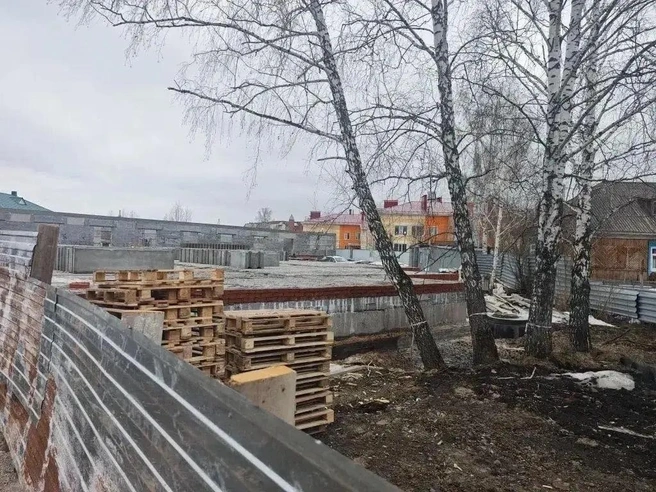 Фото скандальной стройки. Виднеется здание детсада с оранжевой облицовкой | Источник:  Дарья Коршунова