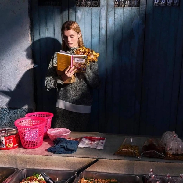 Модель читает книгу, стоя у прилавка | Источник: kris_grikaite / instagram*