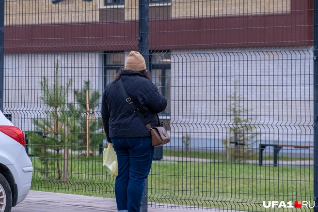 Еще одна мама наблюдает из-за забора, как ее ребенок благополучно зашел в школу | Источник: Булат Салихов / UFA1.RU