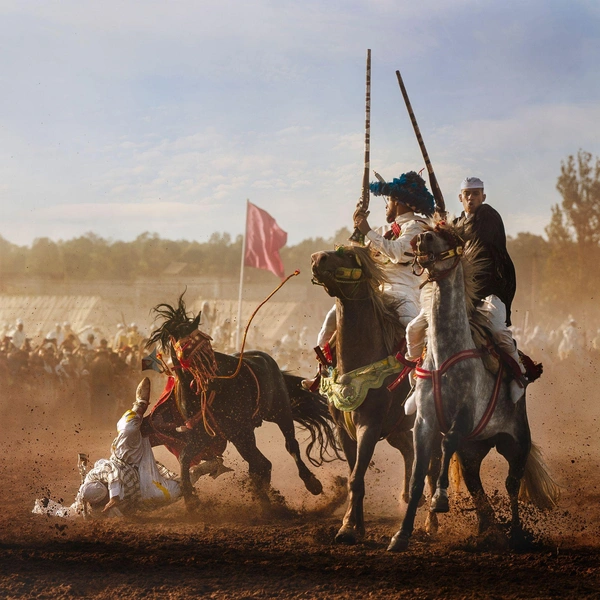 Фотография, запечатлевшая опасность и волнение момента, когда всадник падает с лошади во время традиционного марокканского конного представления. | Источник: Оливье Уния