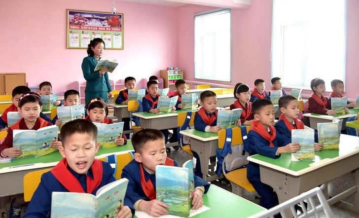 Учащиеся на занятиях в начальной школе в Пхеньяне, Северная Корея. Цвета максимально похожи на классическую советскую школьную форму: красные галстуки, голубые пиджаки у мальчиков и бордово-коричневые платья у девочек | Источник: Ryukyung Website