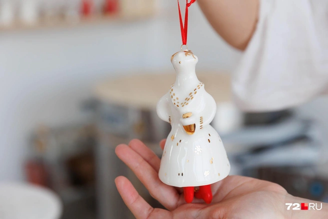 Горожанка звонко шагает в алых сапожках. В руках у нее&nbsp;— стаканчик кофе, платье сверкает в тысячах городских огней | Источник: Ирина Шарова / 72.RU 