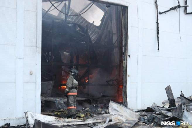 К прибытию пожарных из окон ангара шел густой черный дым | Источник: Андрей Бортко / NGS.RU