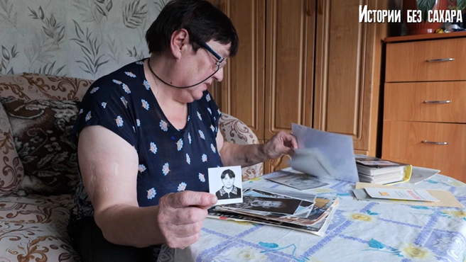 Мама перебирает фотографии дочки | Источник: Истории без сахара. Погребижская. / youtube.com