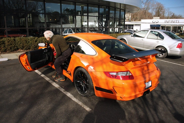 Ральф Лорен садится в свой оранжевый Porsche 997 GT3 RS | Источник: Damian Morys from New York City, United States/Wikimedia Commons