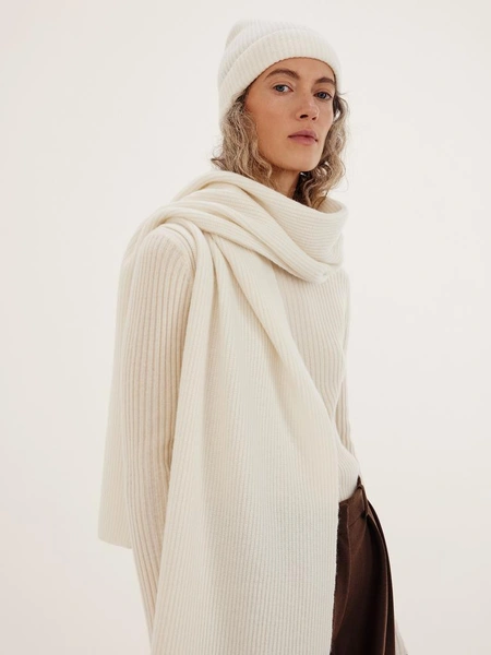 Кашемировый шарф ChaikaБелый шарф из мягкой воздушной пряжи (70% шерсть, 30% кашемир) — универсальная вещь, которая добавляет образу тепла и при этом остается визуально легкой. За счет единого размера его удобно носить по‑разному: накинуть на плечи, обернуть вокруг шеи или комбинировать с верхней одеждой в спокойных, базовых комплектах в духе slow living, который разделяет Chaika.