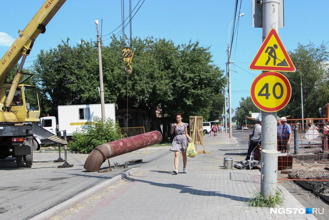 Женщина постаралась очень быстро пройти, чтобы ее не задело трубой | Источник: Варвара Фролова / NGS70.RU