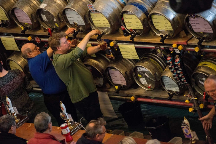 Бармены наливают посетителям эль и стауты на лондонском фестивале пива и сидра Drinker в Камден-центре. Лондон, Англия, 2 марта 2016 года | Источник: Chris Ratcliffe/Getty Images