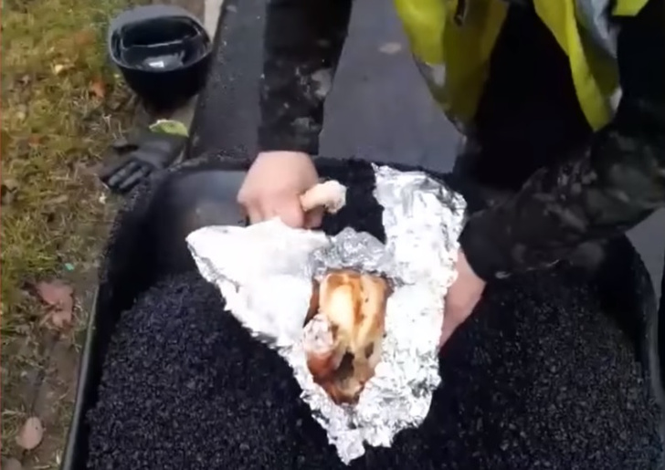 Дорожные рабочие приготовили курицу, засыпав ее раскаленным асфальтом (видео)