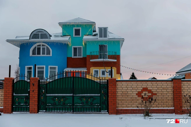 Огромный дом привлекает внимание не только дизайном, но и своей расцветкой. Украшено аккуратно и золотистой гирляндой сверху | Источник: Ирина Шарова / 72.RU