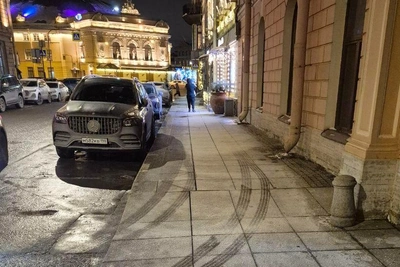 Прохожие оставляют следы на засоленных тротуарах Петербурга