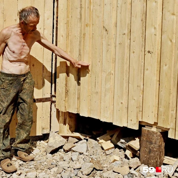Николай показывает, какой был уровень воды  | Источник: Ирина Тропина / 59.RU